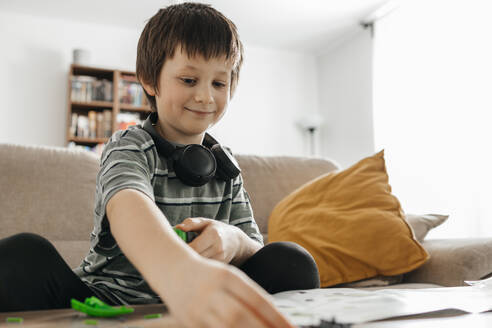 Boy reading instruction manual to make toy model at home - ELMF00037