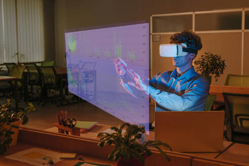 Businessman interacting with graphical interface using virtual reality simulator in office - YTF01887