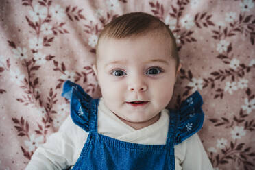 Baby girl lying on bed in bedroom - EBBF08798