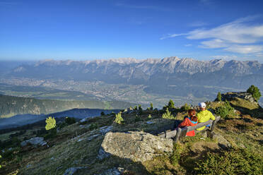 Österreich, Tirol, Zwei Wanderer machen Pause auf einer Bergbank - ANSF00758