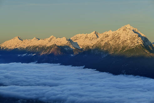 Österreich, Tirol, Alpenglühen über nebelverhangenem Tal in der Morgendämmerung - ANSF00780