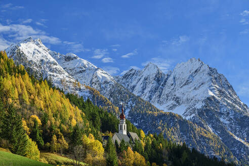 Österreich, Tirol, Wallfahrtskirche Kaltenbrunn inmitten von Herbstbäumen - ANSF00787