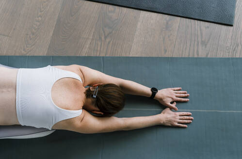 Woman doing child's yoga pose at gym - NDEF01596