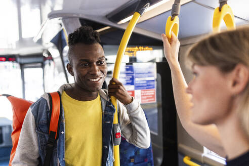 Lächelnder Mann, der mit einem Freund in einem Doppeldeckerbus reist - WPEF08523