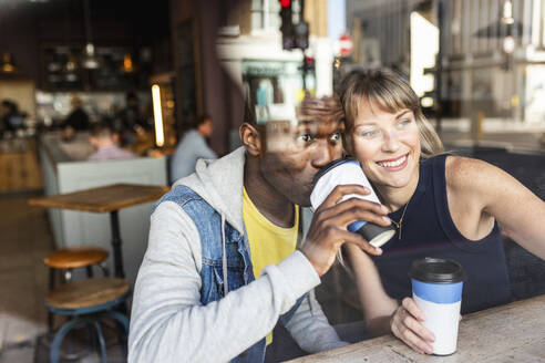 Neugierige multirassische Freunde trinken Kaffee und schauen aus dem Fenster - WPEF08528