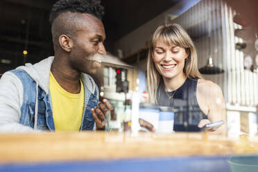 Happy young friends enjoying together at coffee shop - WPEF08529