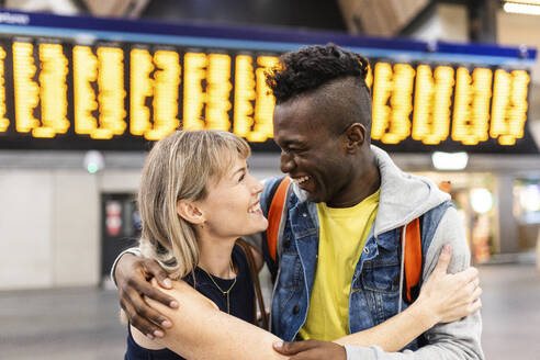 Glückliche multirassische Freunde, die sich am Bahnhof in den Armen liegen - WPEF08555