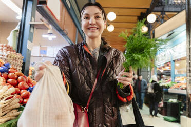 Happy woman buying groceries in market - OSF02441