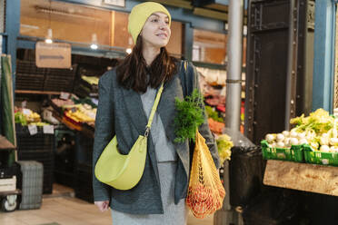 Lächelnde Frau beim Einkauf von Lebensmitteln auf dem Markt - OSF02442