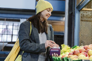 Lächelnde Frau kauft Äpfel auf dem Markt - OSF02446