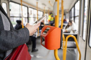 Woman buying ticket through smart phone in tramway - OSF02447