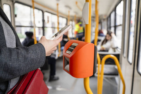 Frau kauft Fahrkarte über Smartphone in der Straßenbahn - OSF02447