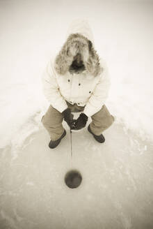 USA, NY, Hammond, High angle view of man ice fishing on frozen Black Lake - TETF02551