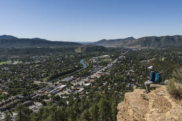 Usa, Colorado, Durango, Frau sitzt auf Felsvorsprung in San Juan Mountains - TETF02555