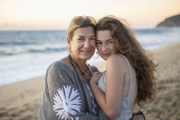 Porträt einer lächelnden Mutter und einer Tochter im Teenageralter am Strand - TETF02581