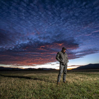 USA, Idaho, Bellevue, Farmer standing in field at sunrise - TETF02586