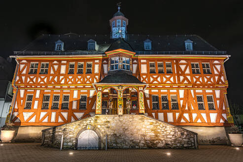Germany, Hesse, Hadamar, Facade of half-timbered town hall at night - MHF00776