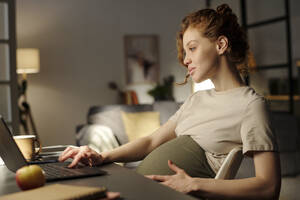 Junge schwangere Freiberuflerin, die von zu Hause aus am Laptop arbeitet - DSHF01611