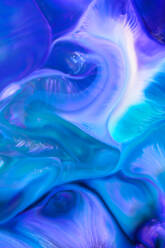 A striking abstract image featuring swirling patterns of blue and green, resembling a fluid or marble backdrop - ADSF53297