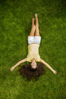 Porträt einer schönen jungen Frau im Freien, die im Gras liegt - INGF12886