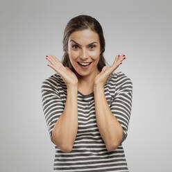 Portrait of a woman after receiving great news, over a gray background - INGF12927