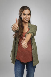 Beautiful woman over a gray background with thumbs up - INGF12933