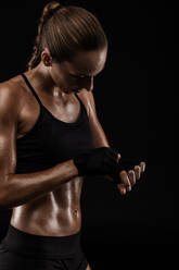 Shot of a beautiful fit young woman getting ready for a kickbox workout - INGF12972