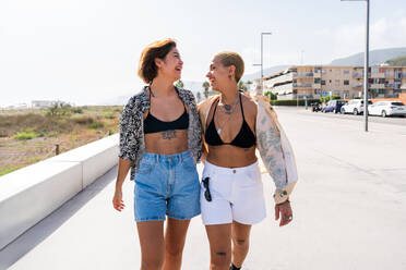Beautiful multiethnic lesbian couple of lovers dating outdoors - LGBT people bonding and spending time together, concepts about LGBTQ community, diversity, love and lifestyle - DMDF10264