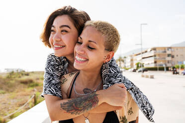 Beautiful multiethnic lesbian couple of lovers dating outdoors - LGBT people bonding and spending time together, concepts about LGBTQ community, diversity, love and lifestyle - DMDF10280