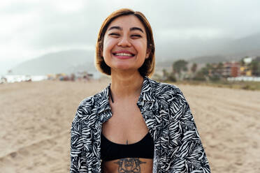 Portrait of beautiful asian young smiling woman at the beach at sunset - DMDF10323