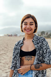 Portrait of beautiful asian young smiling woman at the beach at sunset - DMDF10324