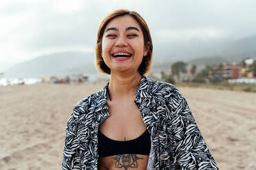 Portrait of beautiful asian young smiling woman at the beach at sunset - DMDF10325