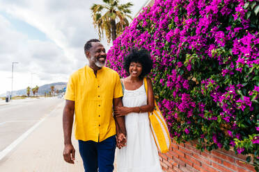 Beautiful mature black couple of lovers dating at the seaside - Married african middle-aged couple bonding and having fun outdoors, concepts about relationship, lifestyle and quality of life - DMDF10370