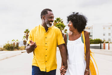 Beautiful mature black couple of lovers dating at the seaside - Married african middle-aged couple bonding and having fun outdoors, concepts about relationship, lifestyle and quality of life - DMDF10378
