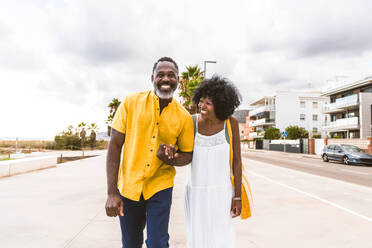 Beautiful mature black couple of lovers dating at the seaside - Married african middle-aged couple bonding and having fun outdoors, concepts about relationship, lifestyle and quality of life - DMDF10381