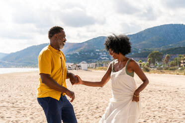 Beautiful mature black couple of lovers dating at the seaside - Married african middle-aged couple bonding and having fun outdoors, concepts about relationship, lifestyle and quality of life - DMDF10383
