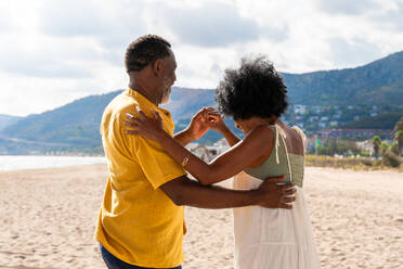 Beautiful mature black couple of lovers dating at the seaside - Married african middle-aged couple bonding and having fun outdoors, concepts about relationship, lifestyle and quality of life - DMDF10384