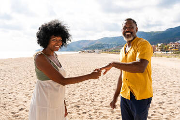 Beautiful mature black couple of lovers dating at the seaside - Married african middle-aged couple bonding and having fun outdoors, concepts about relationship, lifestyle and quality of life - DMDF10400