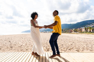 Beautiful mature black couple of lovers dating at the seaside - Married african middle-aged couple bonding and having fun outdoors, concepts about relationship, lifestyle and quality of life - DMDF10405