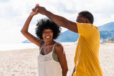 Beautiful mature black couple of lovers dating at the seaside - Married african middle-aged couple bonding and having fun outdoors, concepts about relationship, lifestyle and quality of life - DMDF10406