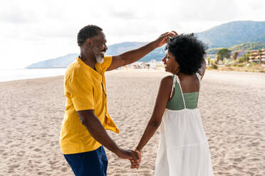 Beautiful mature black couple of lovers dating at the seaside - Married african middle-aged couple bonding and having fun outdoors, concepts about relationship, lifestyle and quality of life - DMDF10407