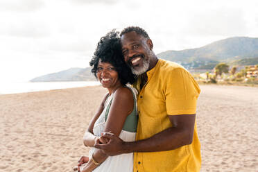 Beautiful mature black couple of lovers dating at the seaside - Married african middle-aged couple bonding and having fun outdoors, concepts about relationship, lifestyle and quality of life - DMDF10410