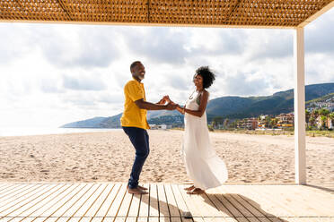 Beautiful mature black couple of lovers dating at the seaside - Married african middle-aged couple bonding and having fun outdoors, concepts about relationship, lifestyle and quality of life - DMDF10412