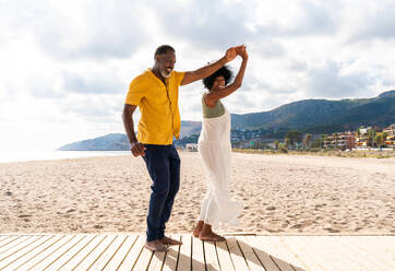 Beautiful mature black couple of lovers dating at the seaside - Married african middle-aged couple bonding and having fun outdoors, concepts about relationship, lifestyle and quality of life - DMDF10414