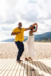 Beautiful mature black couple of lovers dating at the seaside - Married african middle-aged couple bonding and having fun outdoors, concepts about relationship, lifestyle and quality of life - DMDF10415