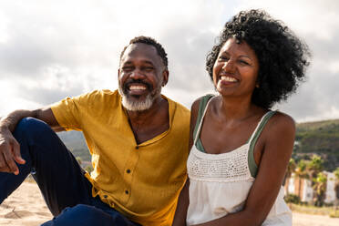 Beautiful mature black couple of lovers dating at the seaside - Married african middle-aged couple bonding and having fun outdoors, concepts about relationship, lifestyle and quality of life - DMDF10435