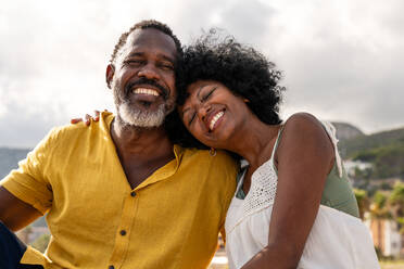 Beautiful mature black couple of lovers dating at the seaside - Married african middle-aged couple bonding and having fun outdoors, concepts about relationship, lifestyle and quality of life - DMDF10437