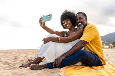 Beautiful mature black couple of lovers dating at the seaside - Married african middle-aged couple bonding and having fun outdoors, concepts about relationship, lifestyle and quality of life - DMDF10449