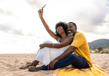 Beautiful mature black couple of lovers dating at the seaside - Married african middle-aged couple bonding and having fun outdoors, concepts about relationship, lifestyle and quality of life - DMDF10450