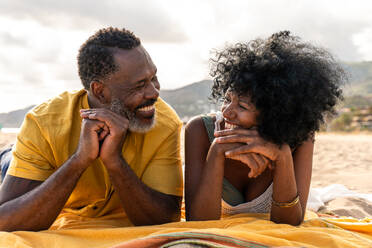 Beautiful mature black couple of lovers dating at the seaside - Married african middle-aged couple bonding and having fun outdoors, concepts about relationship, lifestyle and quality of life - DMDF10457